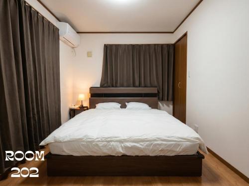 a bedroom with a bed with white sheets and a window at MEME Villa 5BR - 3 Separate Toilets & 3 Showers - 10Gbps Wifi in Tokyo