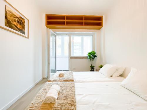 a white bed in a room with a window at Modern 3 Bedroom Apartment Near Belém Lisbon Upto 5 Guests in Cruz Quebrada