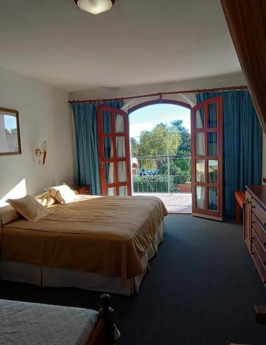 a bedroom with a large bed and an open door at El Cortijo Apart - Hotel in Merlo
