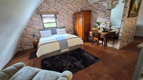 a bedroom with a bed and a dining room at Arch Cabins Self Catering Homes Storms River in Stormsrivier