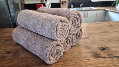 a pile of towels sitting on top of a kitchen counter at Arch Cabins Self Catering Homes Storms River in Stormsrivier