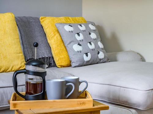 a coffee maker on a tray next to a couch at 2 Bed in Cockermouth oc-87481 in Cockermouth