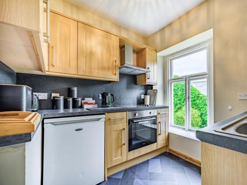 a kitchen with wooden cabinets and a window at 2 Bed in Cockermouth oc-87481 in Cockermouth
