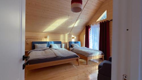 a bedroom with two beds in a wooden room at Eko cottages in Borjomi