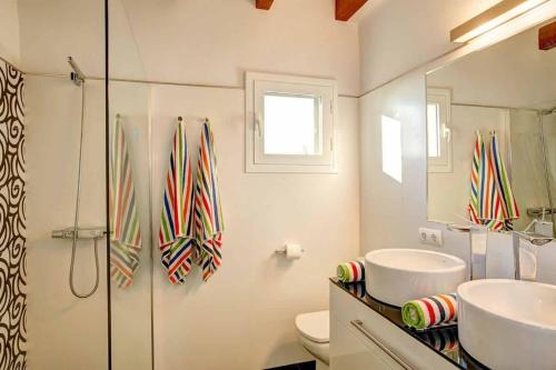 a bathroom with a shower and a sink and a toilet at Villa Sargantana Negra in Binibeca
