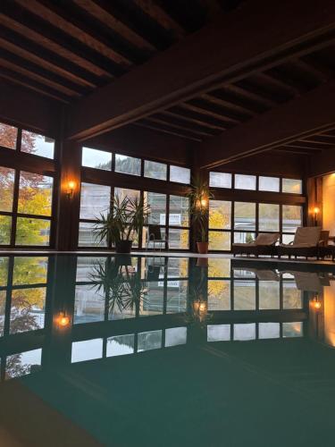 a large room with windows and a reflection in the water at Hotel Wilder Mann in Steinach am Brenner