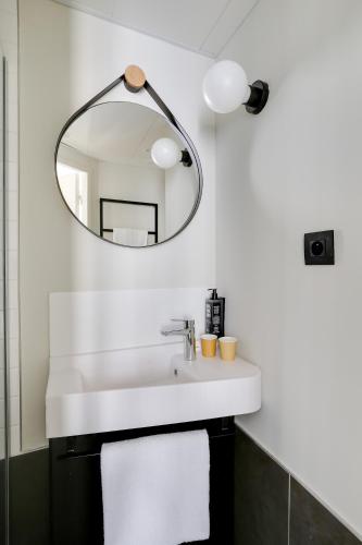 a bathroom with a white sink and a mirror at ibis Levallois Perret in Levallois-Perret