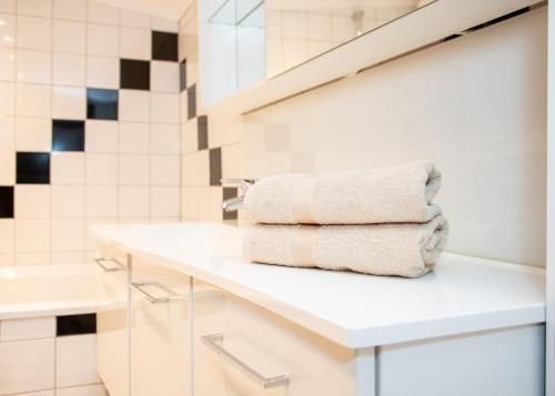 a bathroom with a white sink and towels on a counter at Seehütte Tamberger in Feld am See