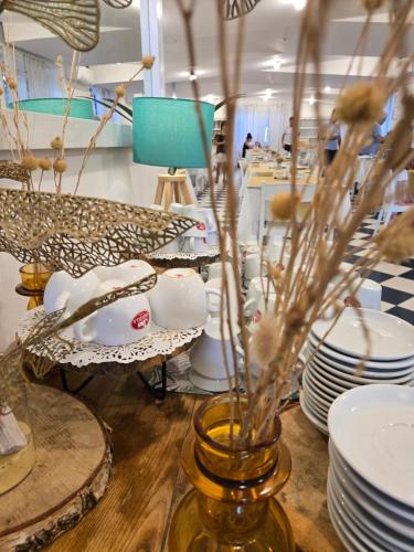 a table with plates and a vase with flowers at Hotel Petit in Silvi Marina