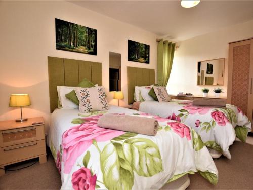 a bedroom with two beds with pink and white sheets at 5 Bed in Alnwick oc-60497 in Alnwick