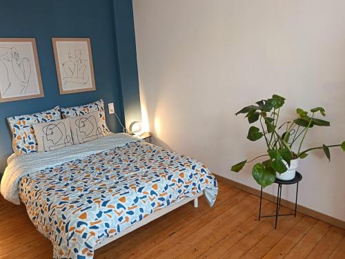 a bedroom with a bed and a potted plant at Renovated charming appartment in Strasbourg