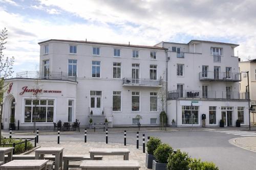 a large white building with tables in front of it at Residenzen am Kirchenplatz in Warnemünde