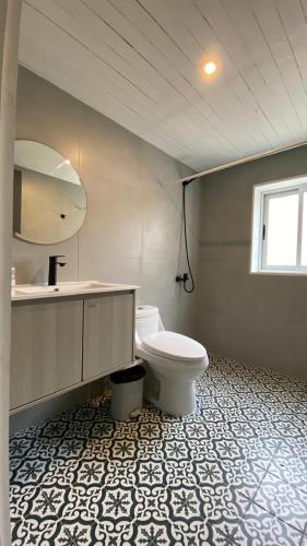 a bathroom with a toilet and a sink and a mirror at Casa Ferrari pichilemu in Pichilemu