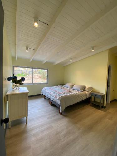 a large bedroom with a bed and a window at Casa Ferrari pichilemu in Pichilemu