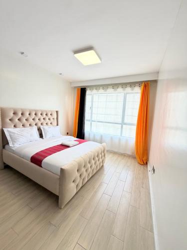 a bedroom with a large bed and a window at Ww homes 2bedroom Apartment in Nairobi
