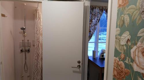 a bathroom with a shower and a door with flowers at Stuga Sandhem in Sandhem