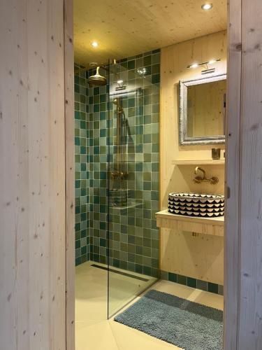 a bathroom with a shower with green tiles at de KruidenPoort in Woudrichem
