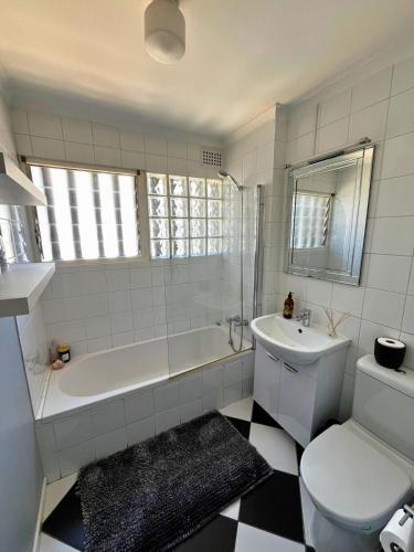 a bathroom with a tub and a toilet and a sink at Derby in Lakeside