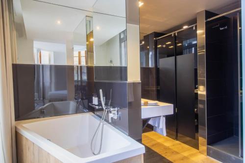 a bathroom with a white tub and a sink at Storni Barcelona by Forget me not in Barcelona
