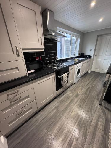 a kitchen with white cabinets and a stove top oven at Central Near Hospital 2 Bedroom - Sleeps 4 - Self Check In - Fully Furnished in Carlisle