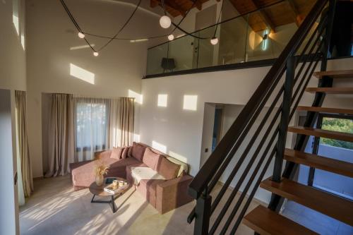 a living room with a couch and a staircase at Malou and Charma Villas in Syvota