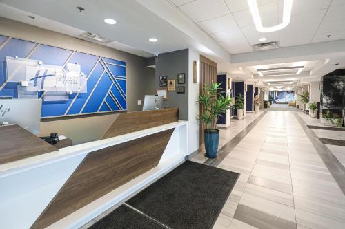 an office lobby with a reception desk and a hallway at Holiday Inn Express Washington DC SW - Springfield by IHG in Springfield