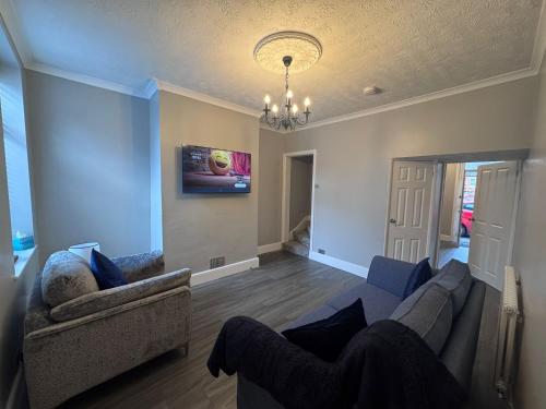 a living room with a couch and a chandelier at Central Near Hospital 2 Bedroom - Sleeps 4 - Self Check In - Fully Furnished in Carlisle