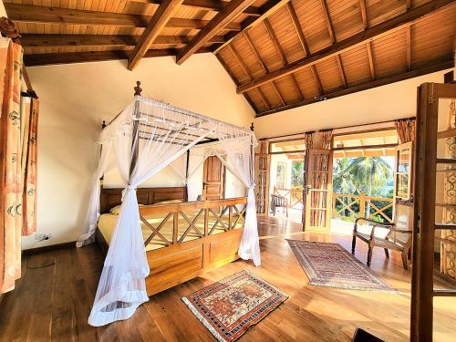 a bedroom with a bed with a mosquito net at Luxury Cannelle lake villa in Hikkaduwa