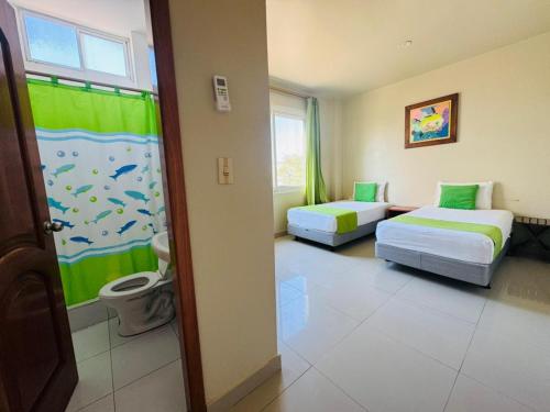a hotel room with two beds and a window at El Rincón de George in Puerto Villamil