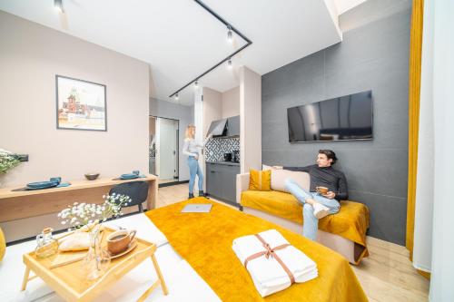 a woman sitting on a couch in a living room at S12 Premium Apartments - by Hosty in Krakow