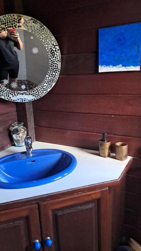 a bathroom with a blue sink and a mirror at Gîte au Carbet in Le Morne aux Bœufs