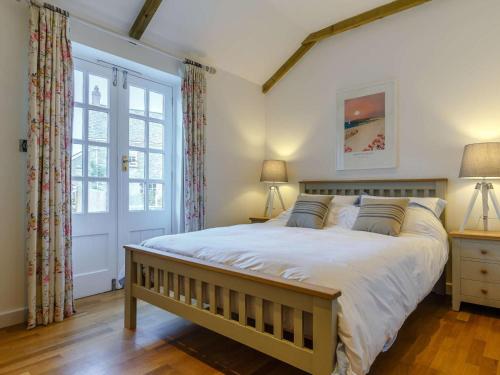 a bedroom with a large bed and a window at 2 Bed in Wadebridge oc-82681 in Little Petherick