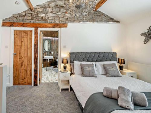 a bedroom with a large bed and a stone wall at 1 Bed in Kendal oc-94210 in Kendal