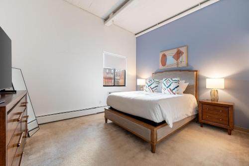 a bedroom with a bed and a dresser and a tv at Landing Apartments - Stockbridge Court in Springfield