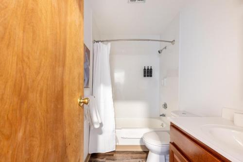 a white bathroom with a toilet and a sink at Landing Apartments - Stockbridge Court in Springfield