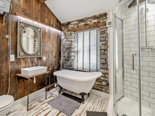a bathroom with a tub and a sink and a mirror at 1 Bed in Kendal oc-94210 in Kendal