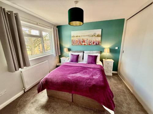 a bedroom with a bed with a purple blanket at Oak View - Spacious 3 Bedroom House near Oxford and the Cotswolds in North Leigh