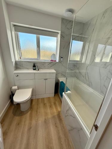 a bathroom with a toilet and a tub and a sink at Oak View - Spacious 3 Bedroom House near Oxford and the Cotswolds in North Leigh