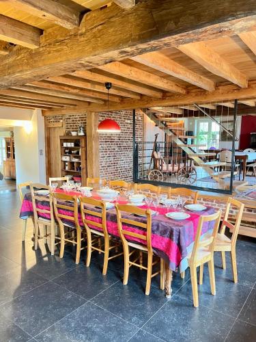 a dining room with a long table and chairs at La Ferme de Beauvoorde - 13 personnes in Steenvoorde