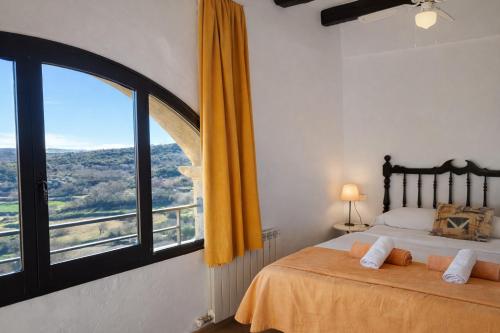 ein Schlafzimmer mit zwei Betten und einem großen Fenster in der Unterkunft Casa amb vista a les muntanyes - Cal Valeri in Montsonis