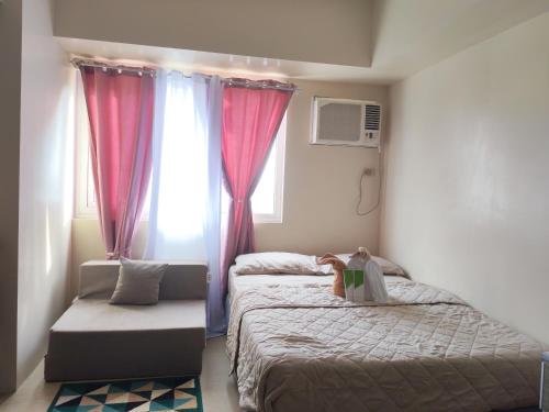 a bedroom with two beds and a window at Avida Davao condo Studio type in Davao City