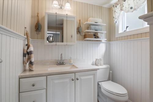 a white bathroom with a toilet and a sink at Eagle's Landing Private Dock Dog Friendly in Acton
