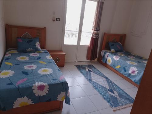 a bedroom with two beds and a window at Nour Tours in Cairo
