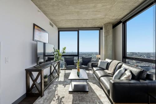 a living room with a couch and large windows at 2BR Designer Loft Modern Luxe in City Center in Chicago