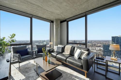 a living room with a couch and chairs and large windows at 2BR Designer Loft Modern Luxe in City Center in Chicago