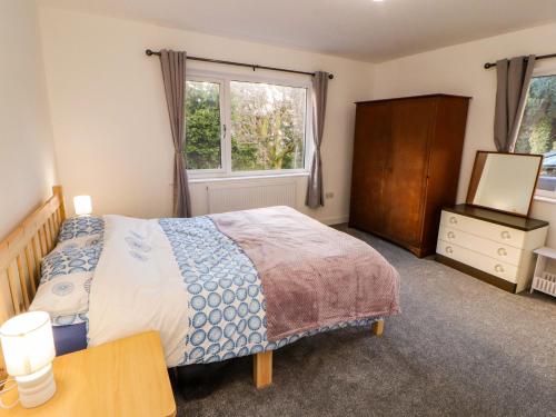 a bedroom with a bed and a dresser and a window at Westerlodge in Keswick