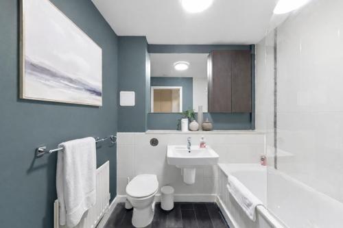 a bathroom with a sink and a toilet at Sleek Apartment with Balcony - City Centre - Free Parking, Fast WiFi and 55'' Smart TV by Yoko Property in Milton Keynes
