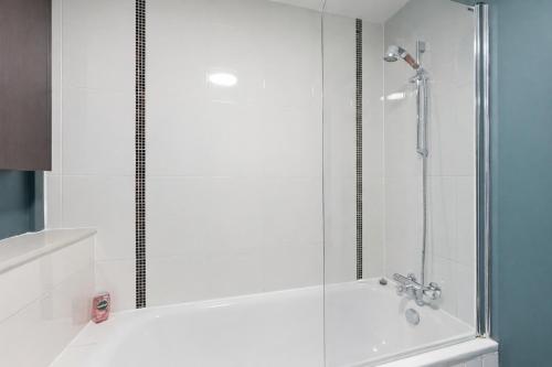a shower with a glass door in a bathroom at Sleek Apartment with Balcony - City Centre - Free Parking, Fast WiFi and 55'' Smart TV by Yoko Property in Milton Keynes