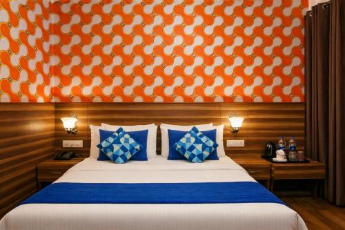 a bedroom with a bed with an orange and white wall at Hotel Vijay Palace Dharamshala Himachal in Dharmsāla