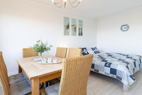 a dining room with a table and a bed at Strandhaferweg 1 Utkiekerblick in Burgtiefe auf Fehmarn 
